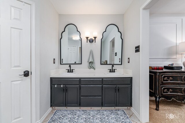 full bathroom with baseboards and double vanity