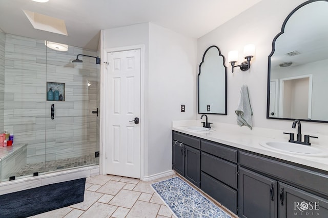 full bathroom with a shower stall, double vanity, baseboards, and a skylight