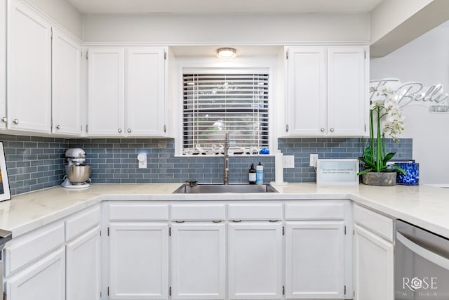 kitchen with a sink, stainless steel dishwasher, and white cabinets