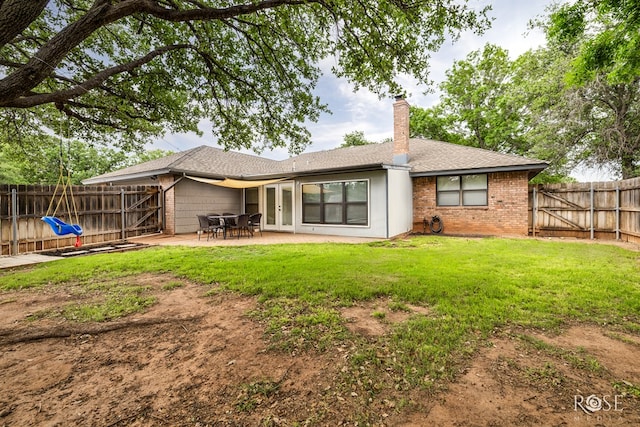 back of property featuring a patio, a chimney, french doors, roof with shingles, and brick siding