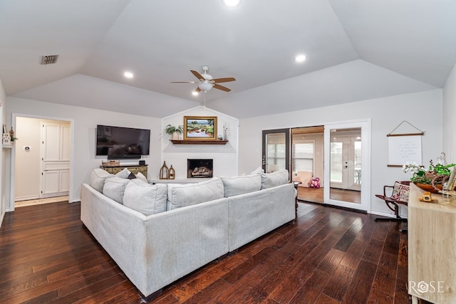 living room featuring vaulted ceiling, a ceiling fan, hardwood / wood-style floors, a brick fireplace, and recessed lighting
