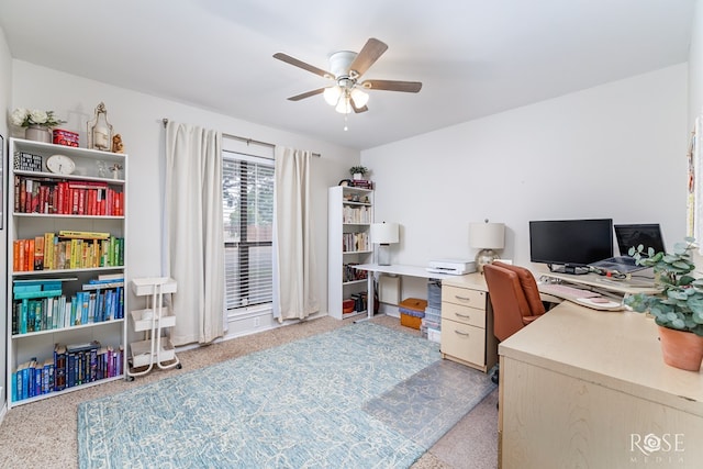 home office with a ceiling fan and light carpet