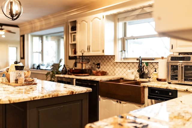 kitchen with dishwasher, light stone countertops, and white cabinets