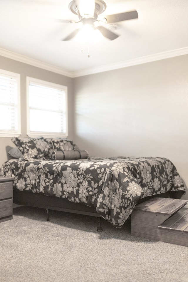 bedroom with crown molding, ceiling fan, and carpet floors