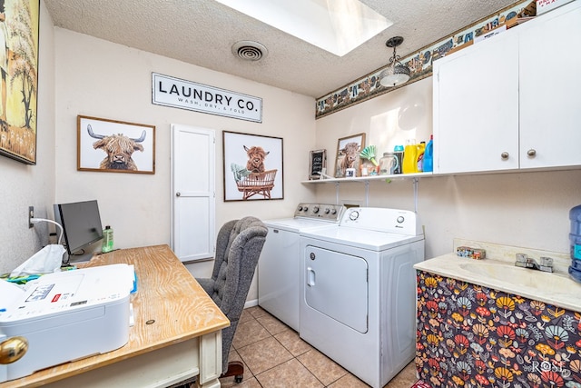 2029 China St, Brady, TX 76825 - laundry area with washer and clothes dryer, a skylight, a textured ceiling, light tile patterned floors, and cabinet space