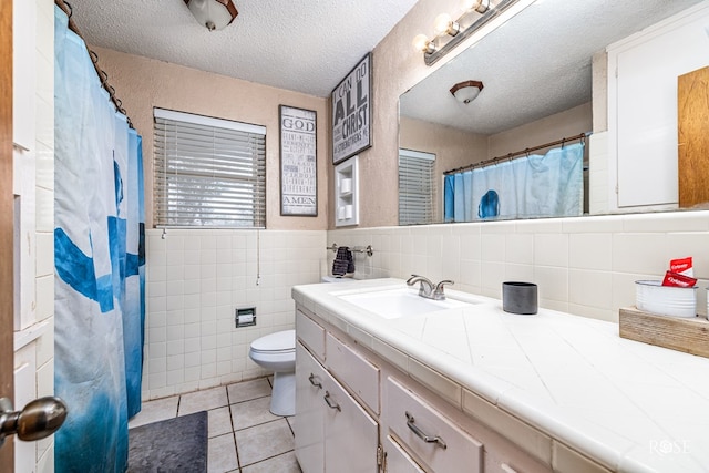 2029 China St, Brady, TX 76825 - bathroom featuring vanity, tile patterned flooring, tile walls, a textured ceiling, and a shower with shower curtain