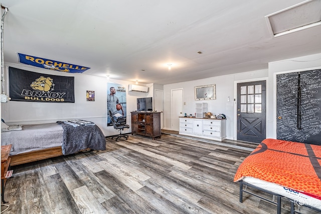 2029 China St, Brady, TX 76825 - bedroom featuring an AC wall unit, wood finished floors, and attic access