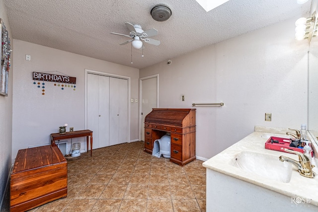 2029 China St, Brady, TX 76825 - interior space featuring a ceiling fan, double vanity, and a textured ceiling