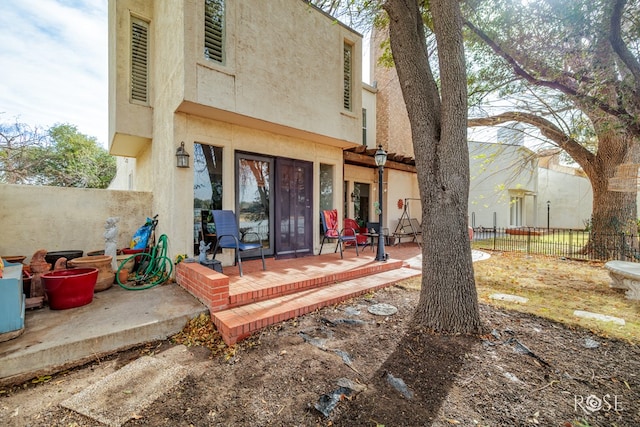 back of property featuring a patio, stucco siding, and fence