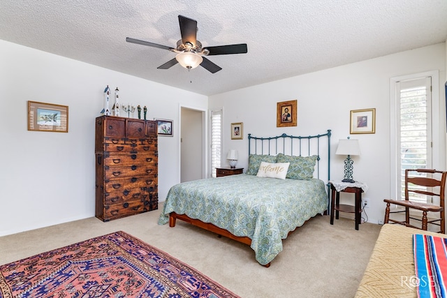 carpeted bedroom featuring a textured ceiling and ceiling fan