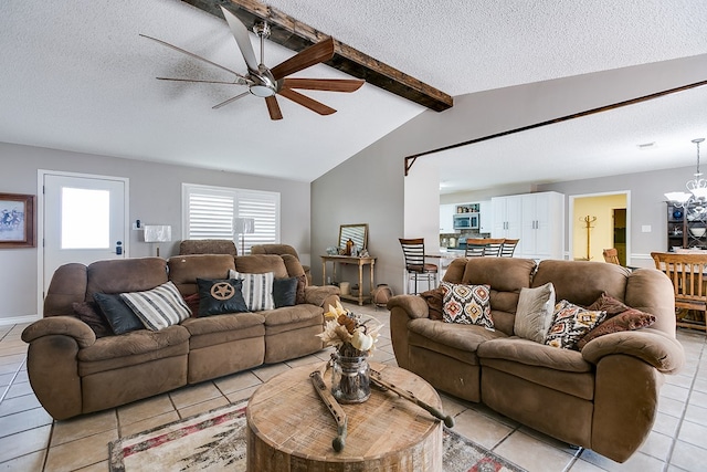 living room featuring ceiling fan with notable chandelier, lofted ceiling with beams, a textured ceiling, and light tile patterned floors