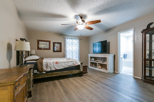 bedroom featuring dark wood-type flooring, connected bathroom, a textured ceiling, and ceiling fan