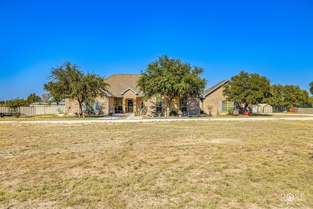 view of front facade with a storage shed and a front yard