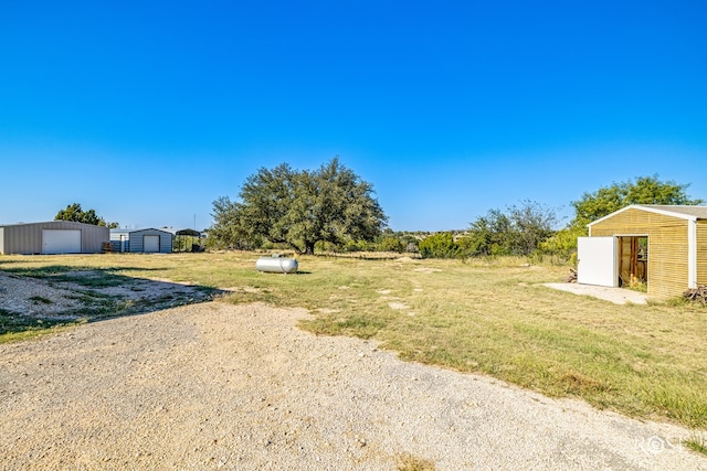 view of yard featuring a garage and an outdoor structure