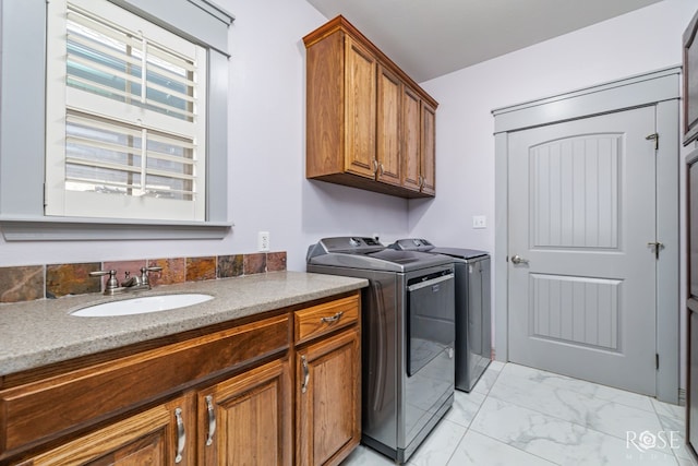 washroom featuring cabinets, separate washer and dryer, and sink