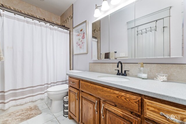 bathroom with marble finish floor, curtained shower, vanity, and toilet