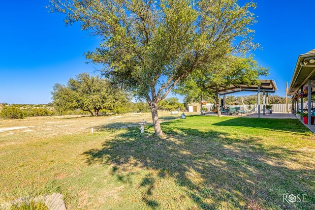 view of yard featuring a patio area, an outdoor structure, and a gazebo