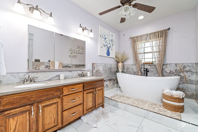 bathroom with a bathing tub, tile walls, vanity, and ceiling fan