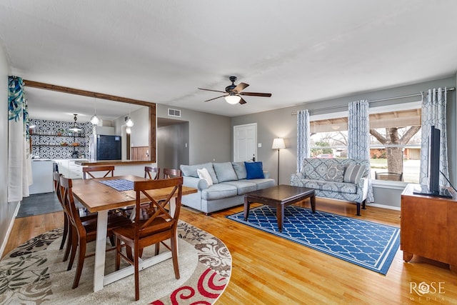 dining room featuring ceiling fan, visible vents, and wood finished floors