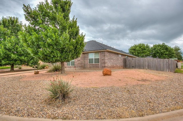 4974 Scarlet Oak Dr, San Angelo, TX 76904 - view of side of home with brick siding and roof with shingles