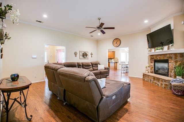 4974 Scarlet Oak Dr, San Angelo, TX 76904 - living area featuring a ceiling fan, wood finished floors, a stone fireplace, ornamental molding, and recessed lighting