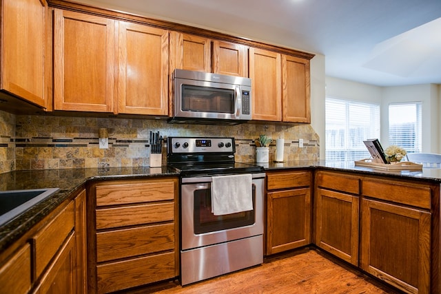 4974 Scarlet Oak Dr, San Angelo, TX 76904 - kitchen featuring stainless steel appliances, decorative backsplash, and brown cabinetry