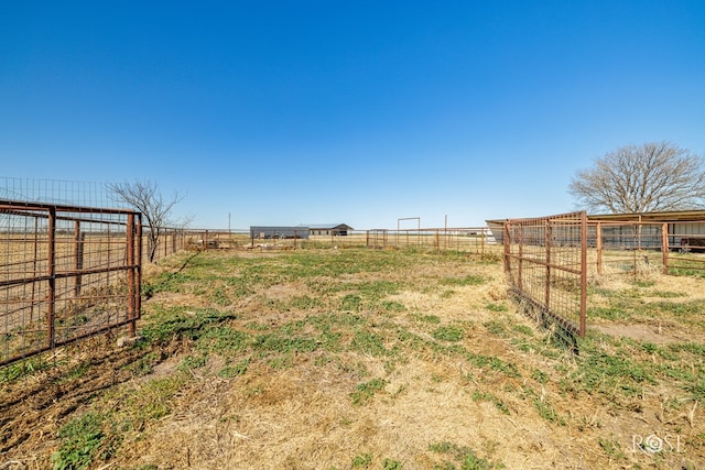 view of yard with a rural view and fence