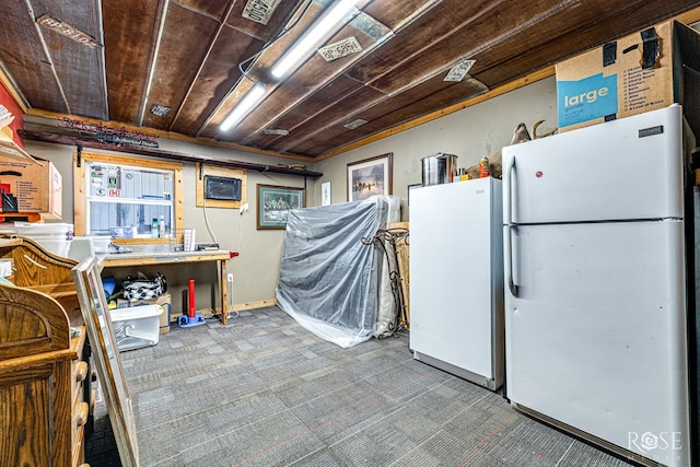 kitchen with wooden ceiling, freestanding refrigerator, and baseboards