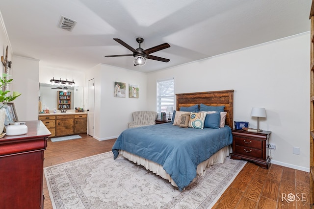 bedroom featuring visible vents, ceiling fan, baseboards, and wood finished floors