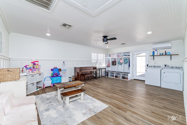 sitting room with visible vents, ornamental molding, wood finished floors, and separate washer and dryer