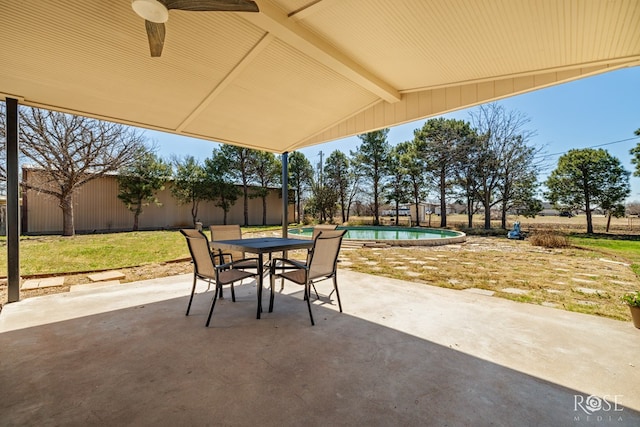 view of patio with outdoor dining area, a ceiling fan, a fenced in pool, and a fenced backyard