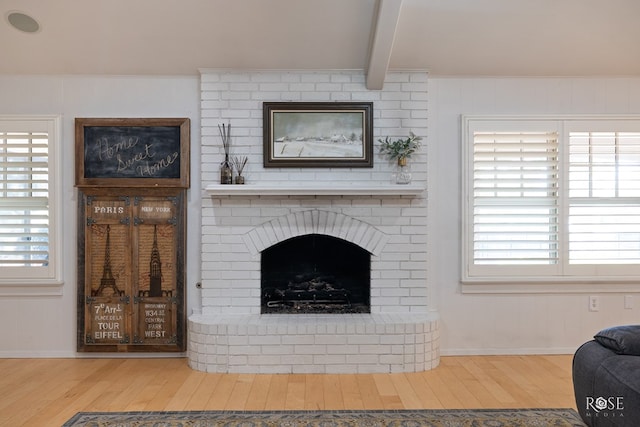 2305 Douglas Dr, San Angelo, TX 76904 - living area with wood finished floors, beam ceiling, baseboards, and a brick fireplace