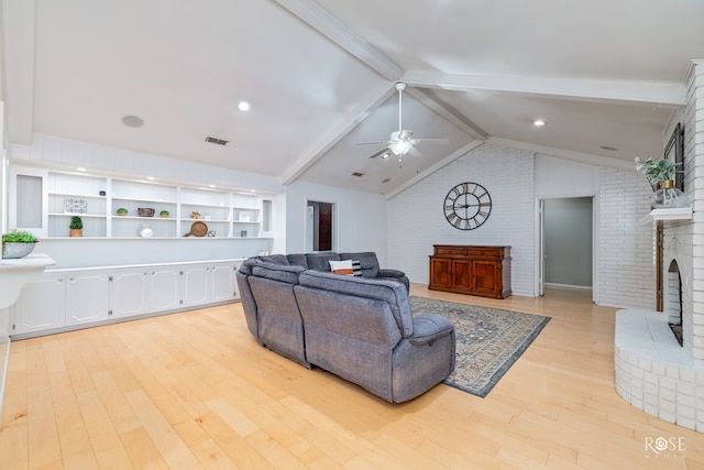 2305 Douglas Dr, San Angelo, TX 76904 - living room with light wood-type flooring, brick wall, ceiling fan, and a brick fireplace