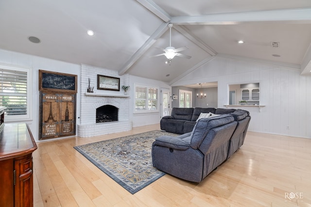 2305 Douglas Dr, San Angelo, TX 76904 - living room with wood finished floors, a ceiling fan, a fireplace, and a chandelier