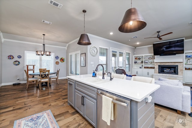 kitchen featuring sink, gray cabinets, dishwasher, pendant lighting, and a kitchen island with sink