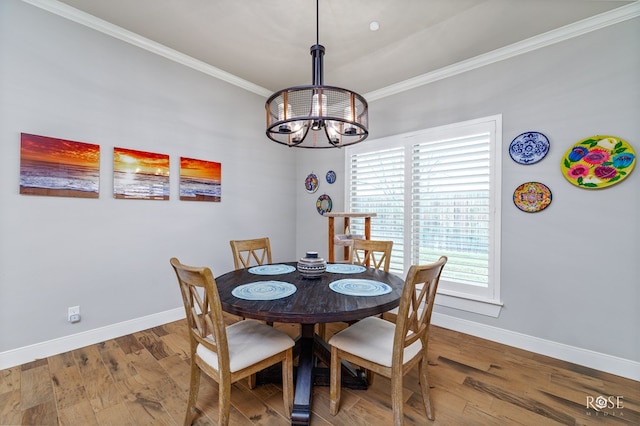 dining space featuring hardwood / wood-style flooring, ornamental molding, and an inviting chandelier