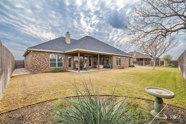 rear view of house with a patio area and a lawn