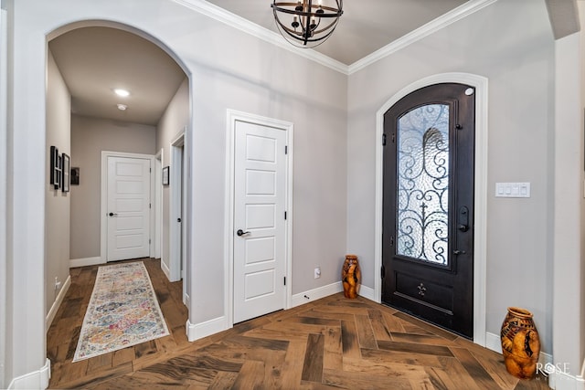 entrance foyer featuring crown molding, a healthy amount of sunlight, a chandelier, and dark parquet floors