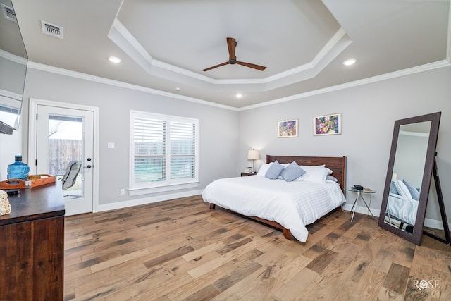 bedroom featuring crown molding, ceiling fan, light hardwood / wood-style floors, access to outside, and a raised ceiling