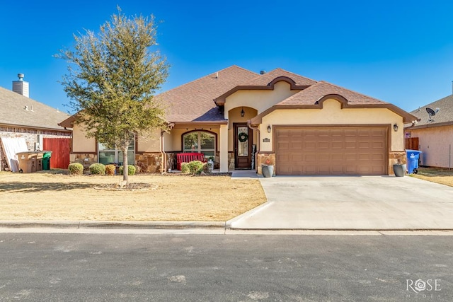 view of front of home with concrete driveway, stone siding, an attached garage, fence, and stucco siding