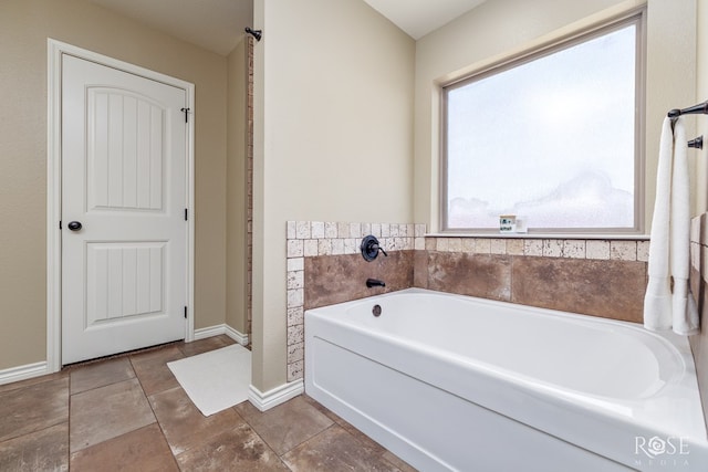 full bath featuring a bath and baseboards