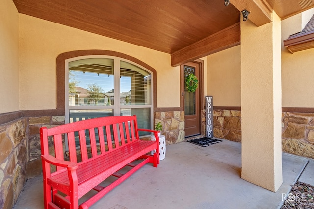 property entrance with stone siding and stucco siding