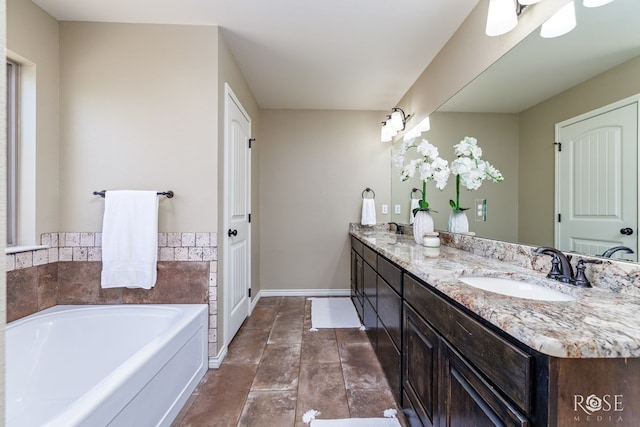 full bath featuring double vanity, baseboards, a sink, and a bath