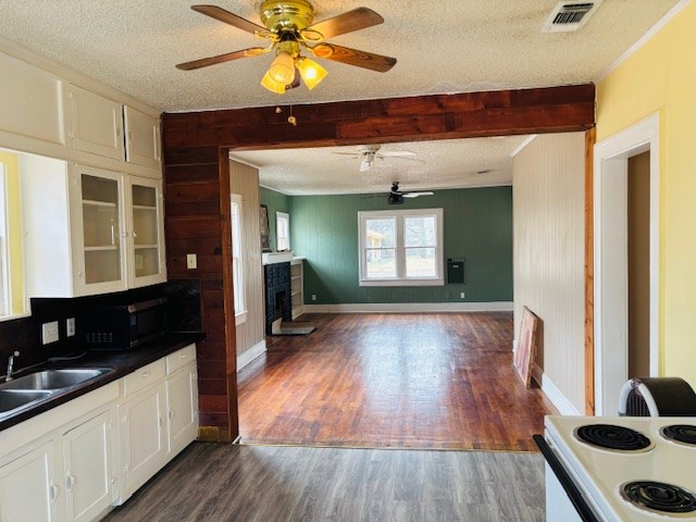 kitchen featuring a textured ceiling, white cabinets, and dark hardwood / wood-style flooring