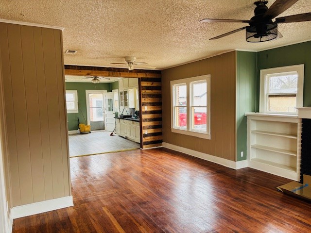 spare room featuring hardwood / wood-style floors, a healthy amount of sunlight, and a fireplace