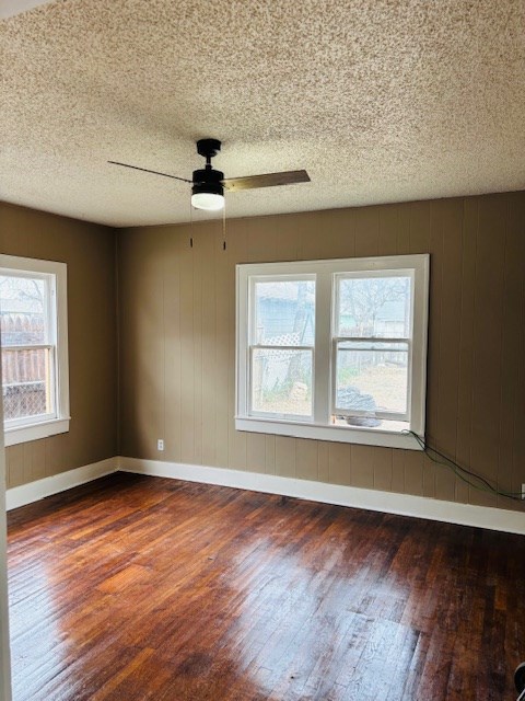 spare room featuring a textured ceiling, ceiling fan, and dark hardwood / wood-style flooring