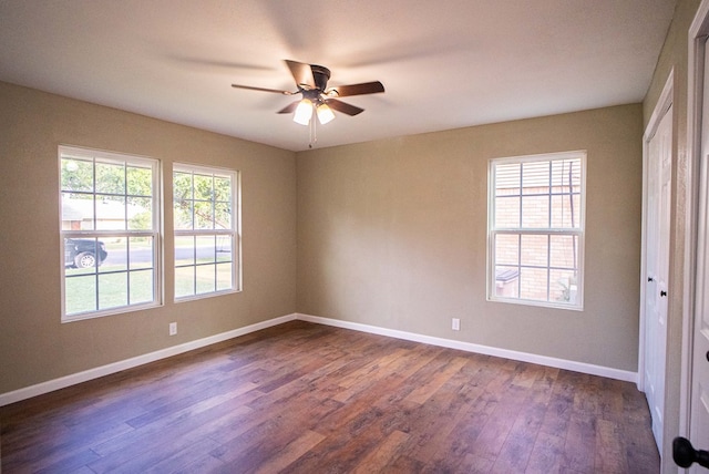 empty room with dark hardwood / wood-style floors and ceiling fan