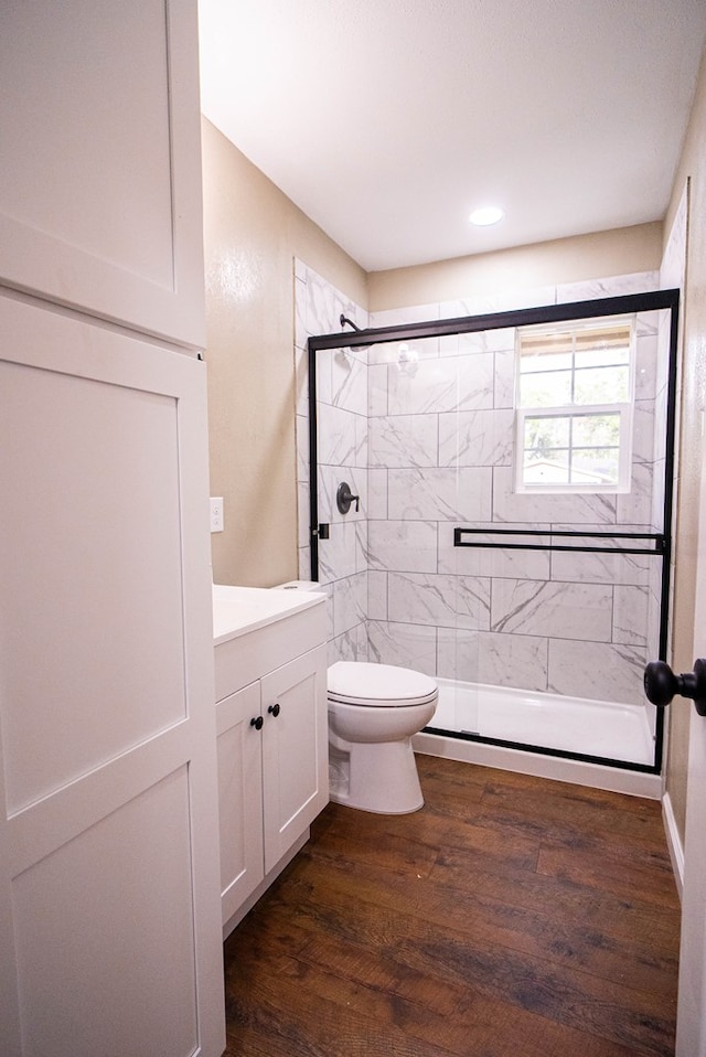 bathroom with vanity, hardwood / wood-style floors, toilet, and an enclosed shower