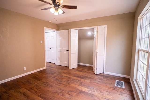 unfurnished bedroom with dark wood-type flooring and ceiling fan