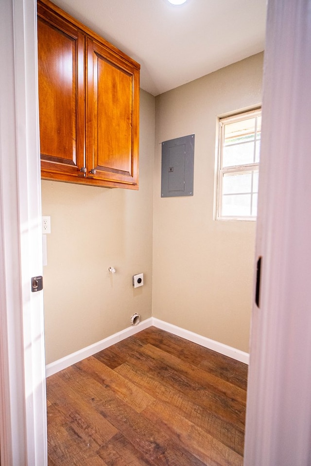 washroom with dark wood-type flooring, cabinets, electric panel, and electric dryer hookup